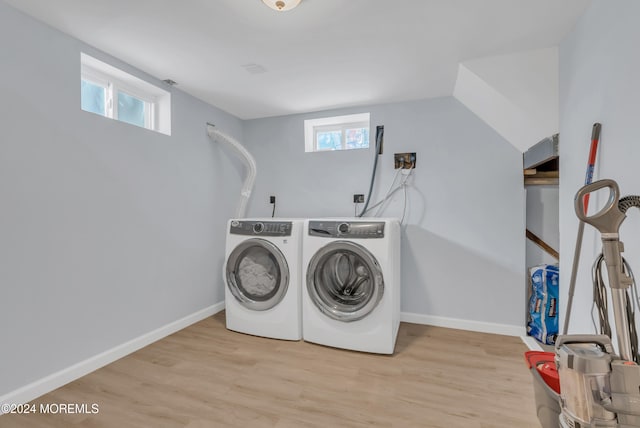 laundry room featuring washing machine and clothes dryer and light hardwood / wood-style floors