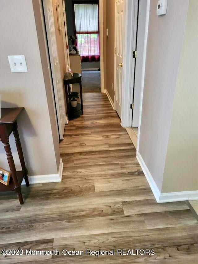 hallway with hardwood / wood-style floors