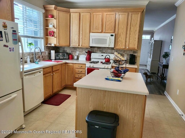 kitchen with tasteful backsplash, a kitchen island, crown molding, sink, and white appliances