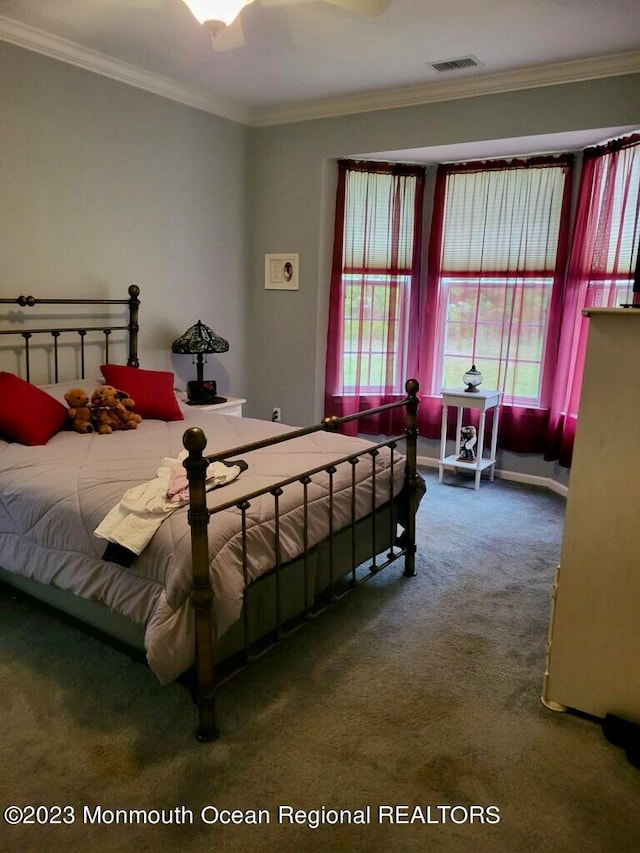 carpeted bedroom featuring crown molding and ceiling fan