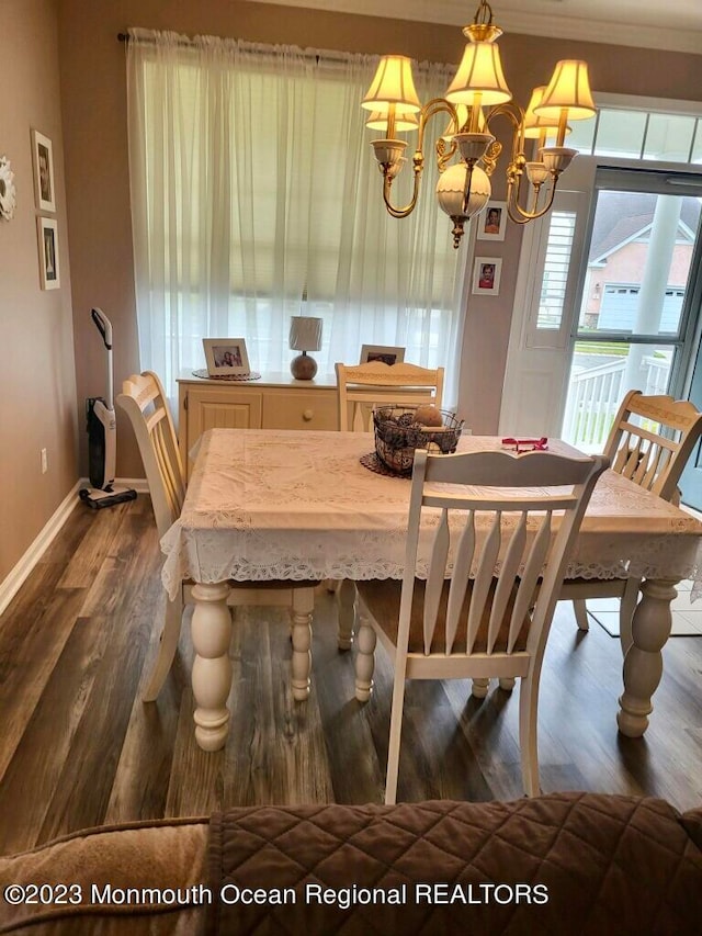 dining space featuring crown molding, a notable chandelier, and dark hardwood / wood-style flooring