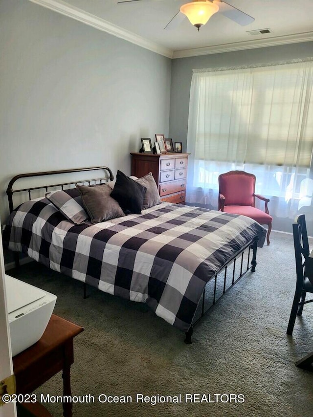 bedroom featuring ceiling fan, crown molding, and dark colored carpet