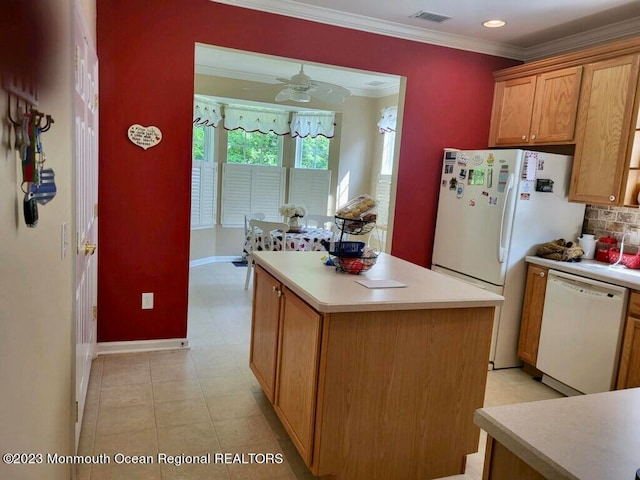 kitchen with white appliances, tasteful backsplash, a kitchen island, ceiling fan, and crown molding