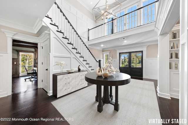 entrance foyer featuring dark wood-type flooring, plenty of natural light, french doors, and crown molding