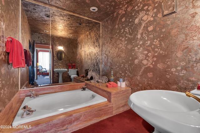 bathroom with sink and tiled tub