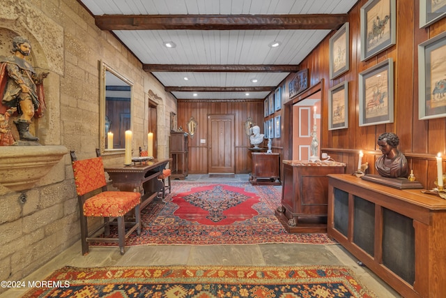 interior space with wood walls, wooden ceiling, and beamed ceiling