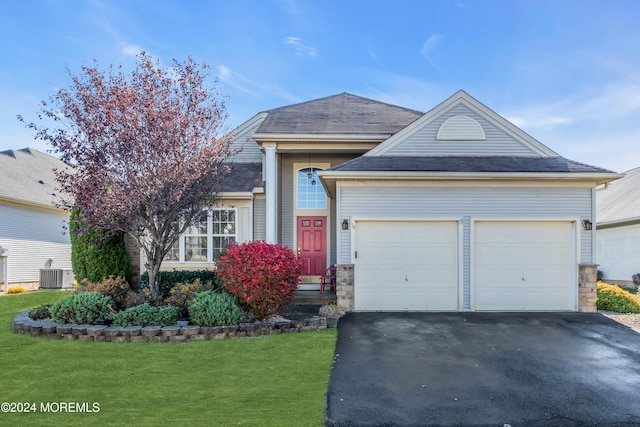 view of front facade with a garage, central AC, and a front lawn