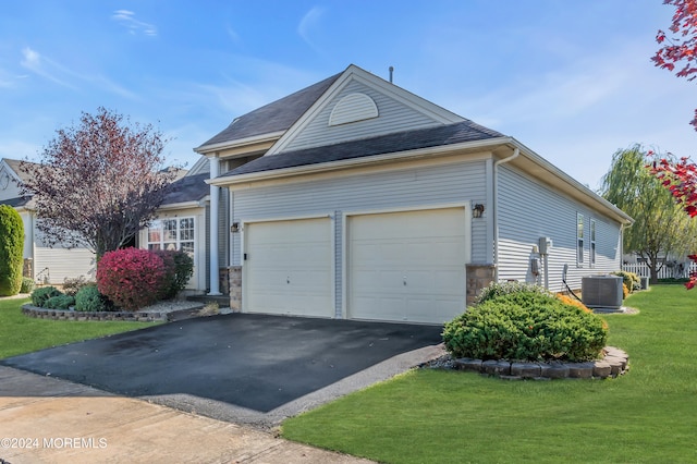 view of front of home featuring a garage, central AC unit, and a front lawn