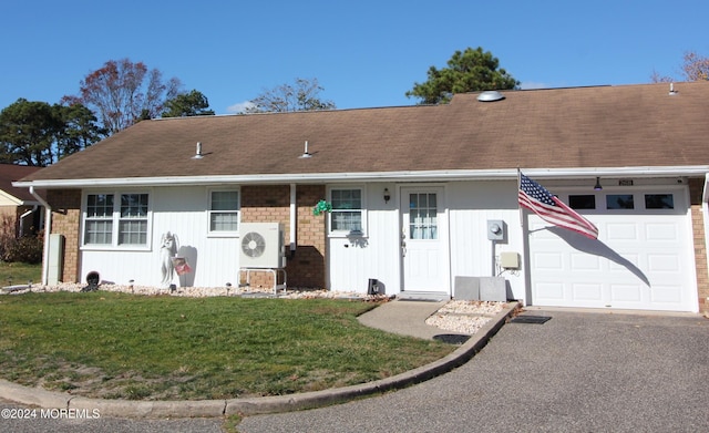 ranch-style house with a garage and a front lawn