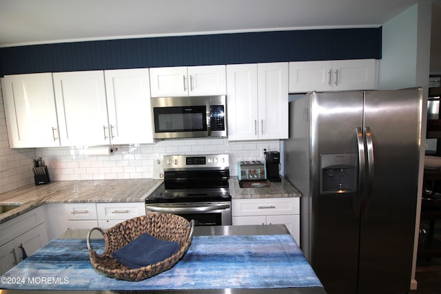 kitchen with decorative backsplash, white cabinets, light stone countertops, and appliances with stainless steel finishes