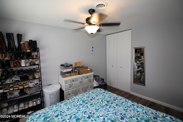 bedroom with ceiling fan, dark wood-type flooring, and a closet