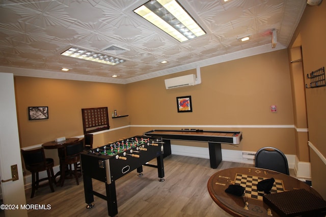 playroom with a wall mounted air conditioner and hardwood / wood-style flooring