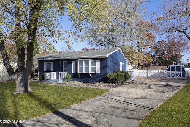 bungalow-style house with a front yard and a shed