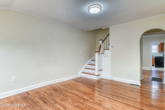 spare room with hardwood / wood-style floors and crown molding