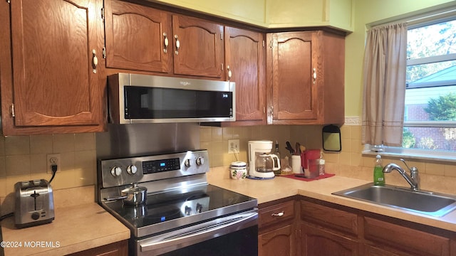 kitchen with decorative backsplash, appliances with stainless steel finishes, and sink