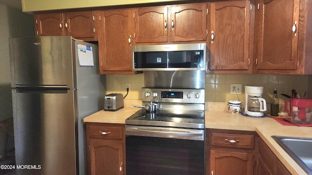 kitchen featuring appliances with stainless steel finishes, sink, and tasteful backsplash