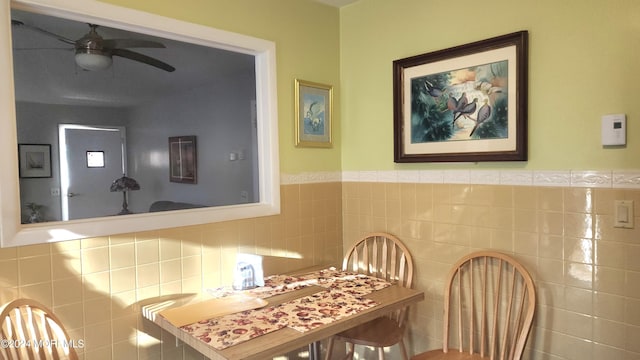 dining space featuring tile walls