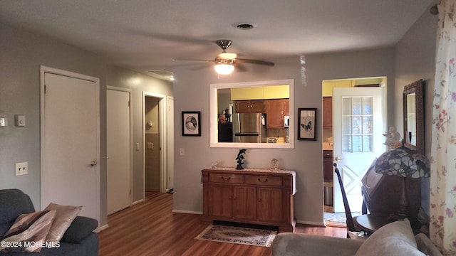 living room with dark hardwood / wood-style flooring and ceiling fan