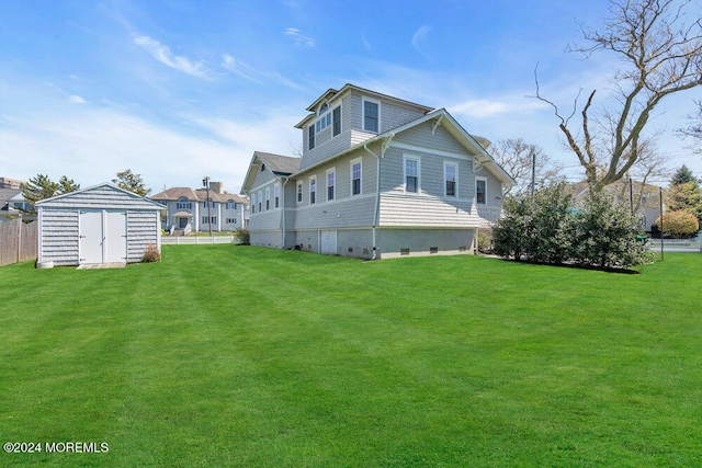 rear view of property with a storage shed and a yard