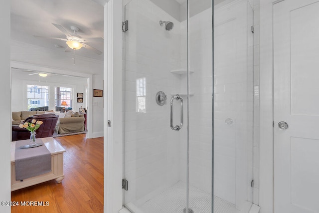 bathroom featuring hardwood / wood-style floors, a shower with door, and ceiling fan