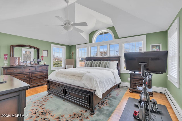 bedroom featuring light hardwood / wood-style floors, multiple windows, vaulted ceiling, and ceiling fan