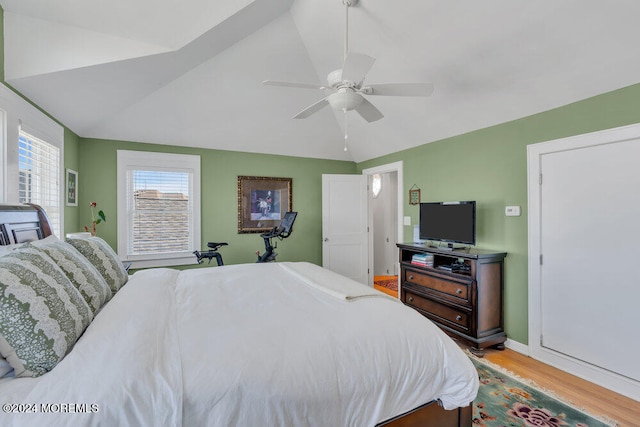 bedroom with ceiling fan, light hardwood / wood-style flooring, and lofted ceiling