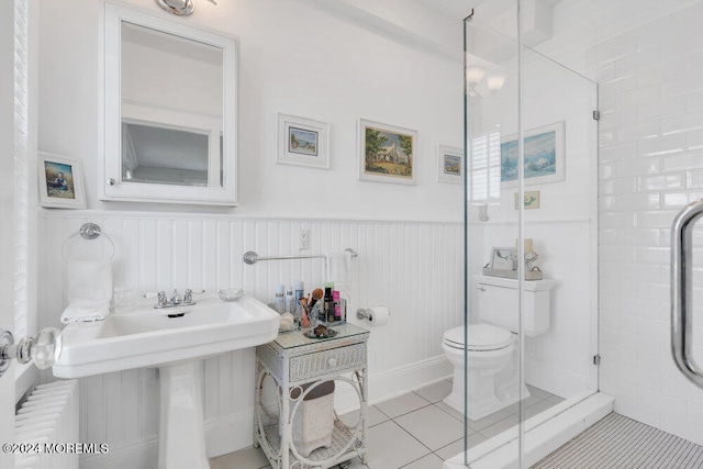 bathroom featuring a shower with shower door, tile patterned floors, and toilet