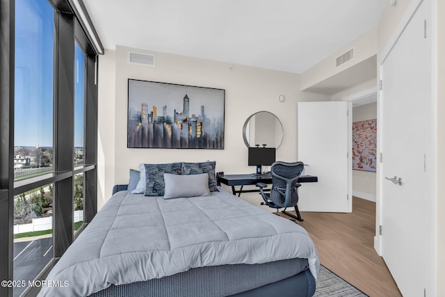 bedroom featuring visible vents, baseboards, and wood finished floors