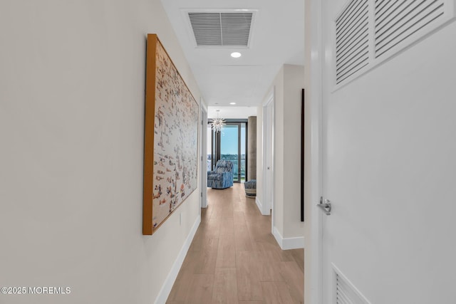 hall with visible vents, baseboards, light wood finished floors, and recessed lighting
