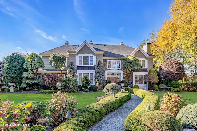 25 Bruns Rd, West Allenhurst, NJ 07711 - view of front facade featuring a chimney, a front lawn, and stone siding