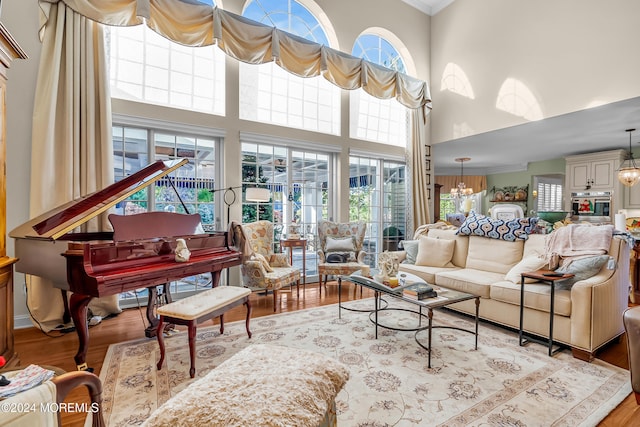 living room with a healthy amount of sunlight, a high ceiling, and an inviting chandelier