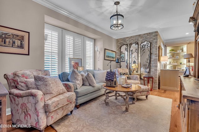 living room featuring a notable chandelier, crown molding, and light hardwood / wood-style flooring