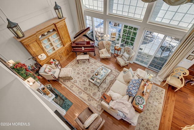 living room with a towering ceiling and hardwood / wood-style floors