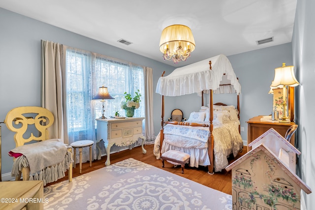 bedroom featuring wood-type flooring and a notable chandelier