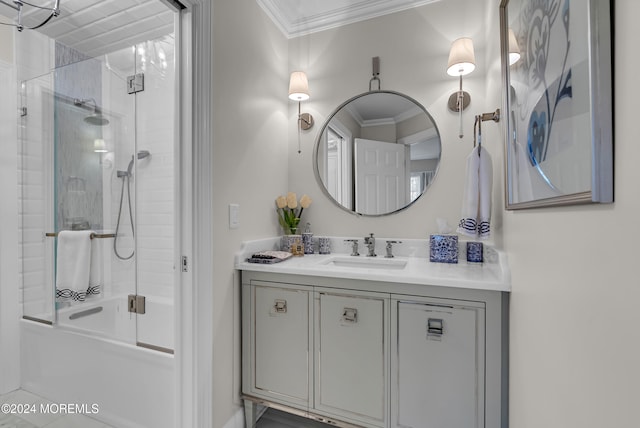 bathroom with ornamental molding, shower / bath combination with glass door, and vanity