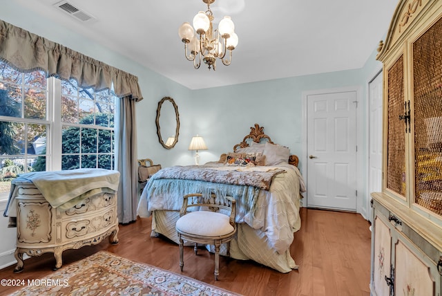 bedroom with light hardwood / wood-style flooring and a notable chandelier