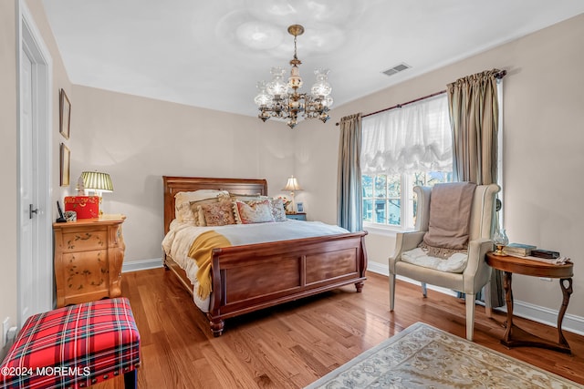 bedroom featuring wood-type flooring and a notable chandelier