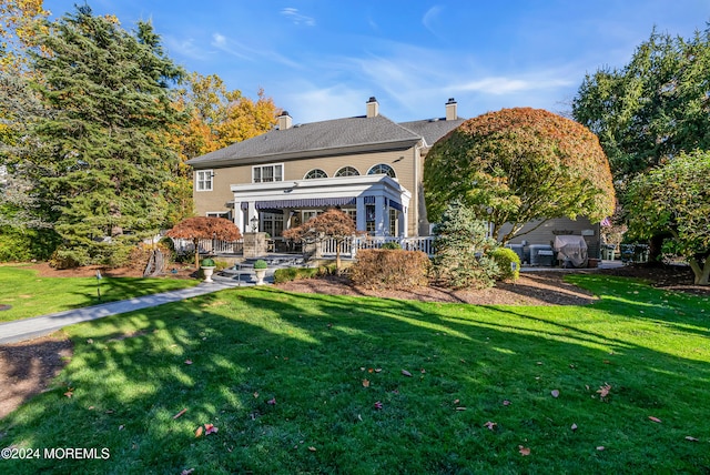 rear view of property with a lawn