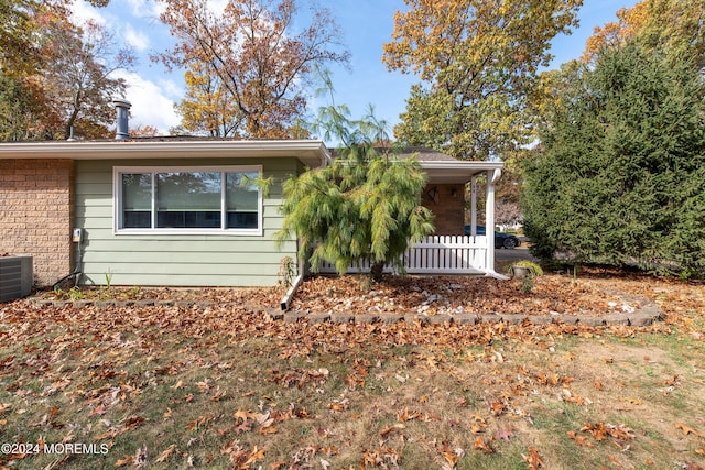 single story home featuring central AC unit and a porch