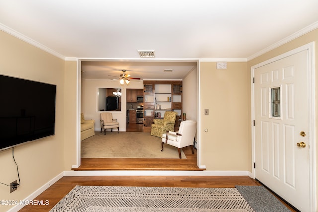 entrance foyer with ornamental molding, hardwood / wood-style floors, and ceiling fan