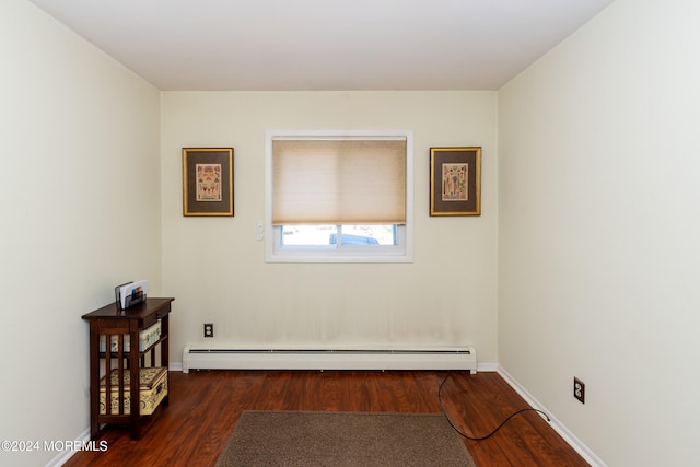 unfurnished room featuring dark hardwood / wood-style floors and a baseboard heating unit