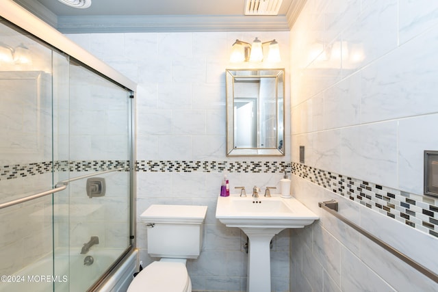 bathroom with shower / bath combination with glass door, crown molding, and tile walls