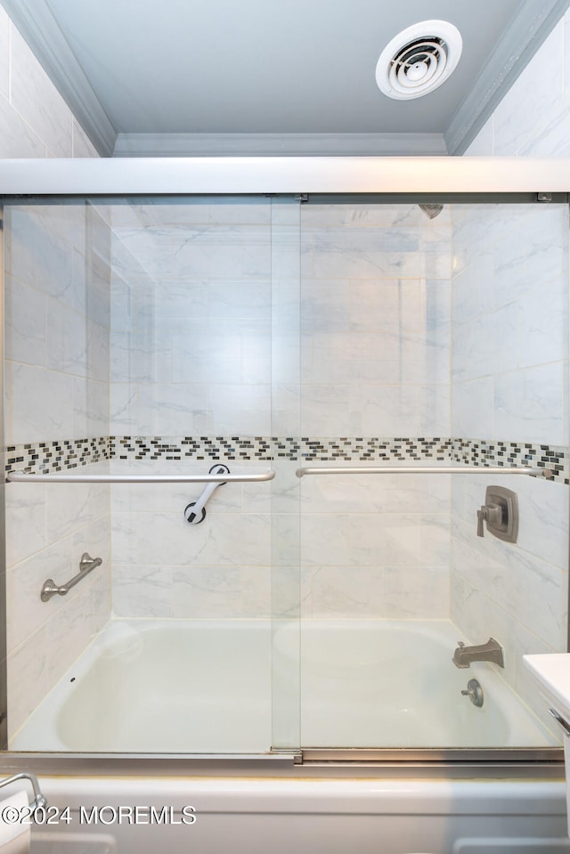 bathroom featuring enclosed tub / shower combo and crown molding