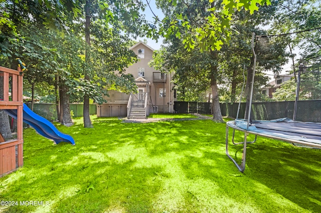 view of yard featuring a playground and a trampoline