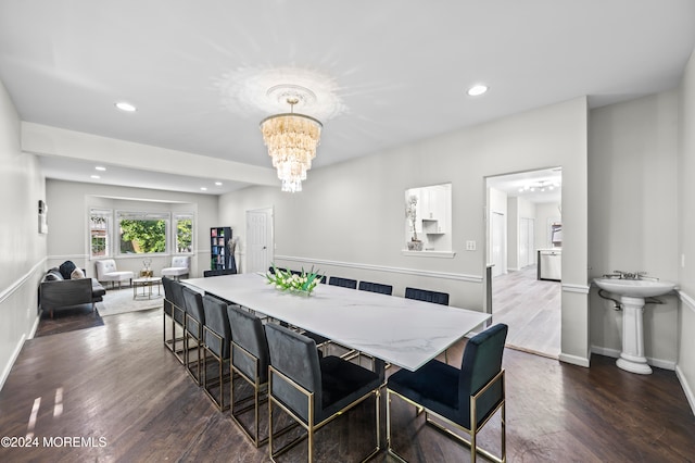 dining area with dark hardwood / wood-style floors and an inviting chandelier