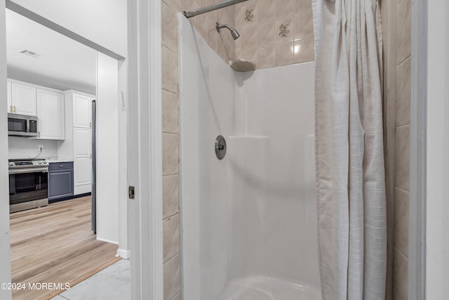 bathroom featuring hardwood / wood-style floors and curtained shower