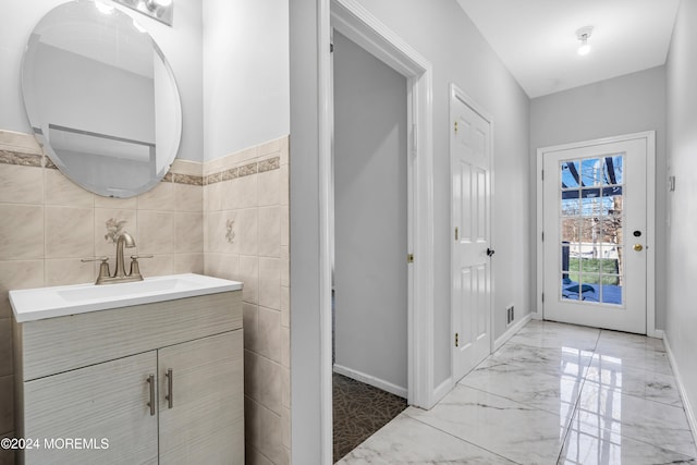 bathroom featuring vanity and tile walls