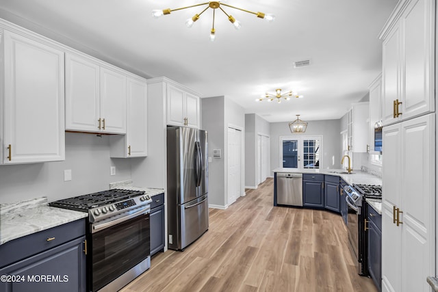 kitchen with white cabinetry, sink, appliances with stainless steel finishes, blue cabinets, and light wood-type flooring