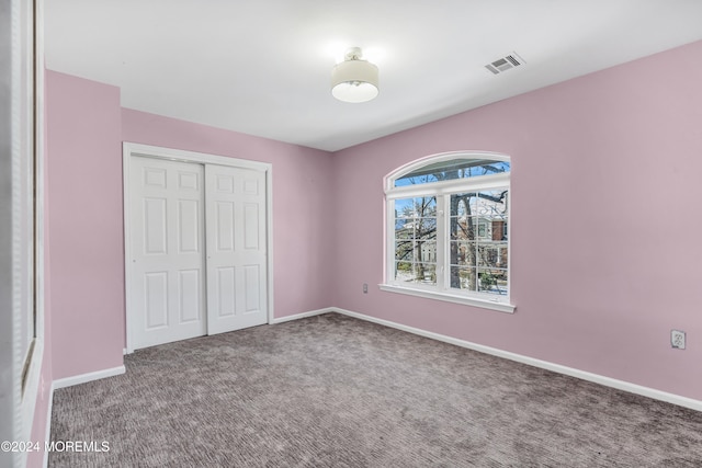 unfurnished bedroom with a closet and carpet floors