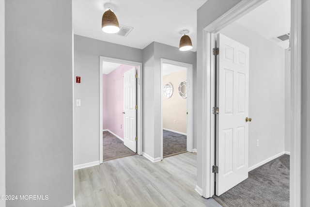 hallway featuring light colored carpet